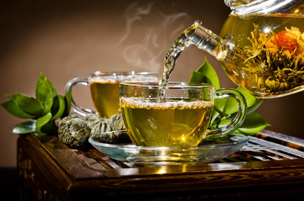 Bule despejando chá verde na xícara