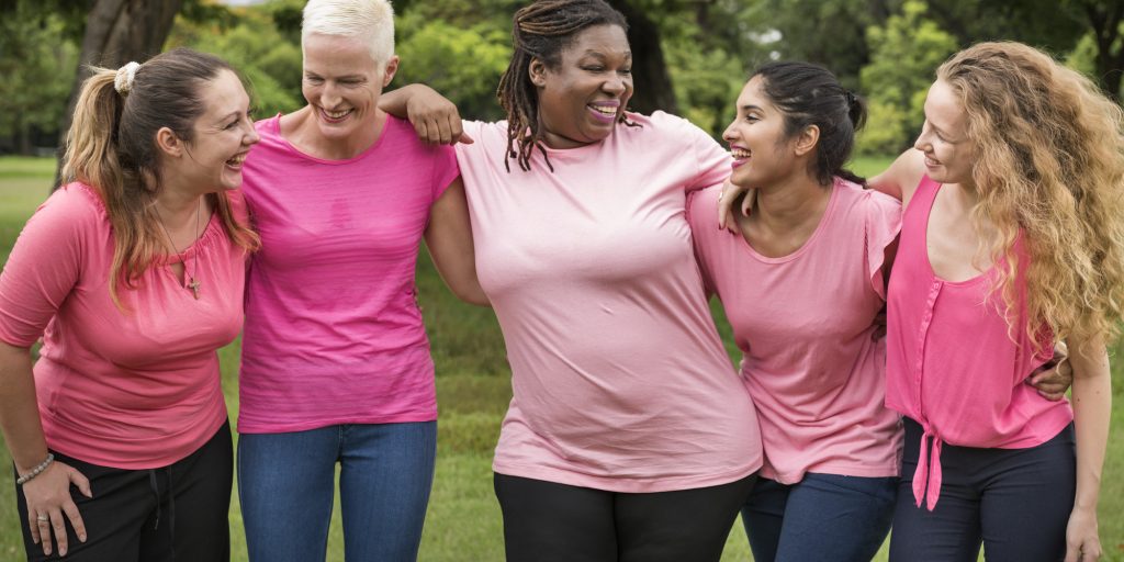 Mulheres de diferentes biótipos vestindo camiseta rosa contra o câncer de mama