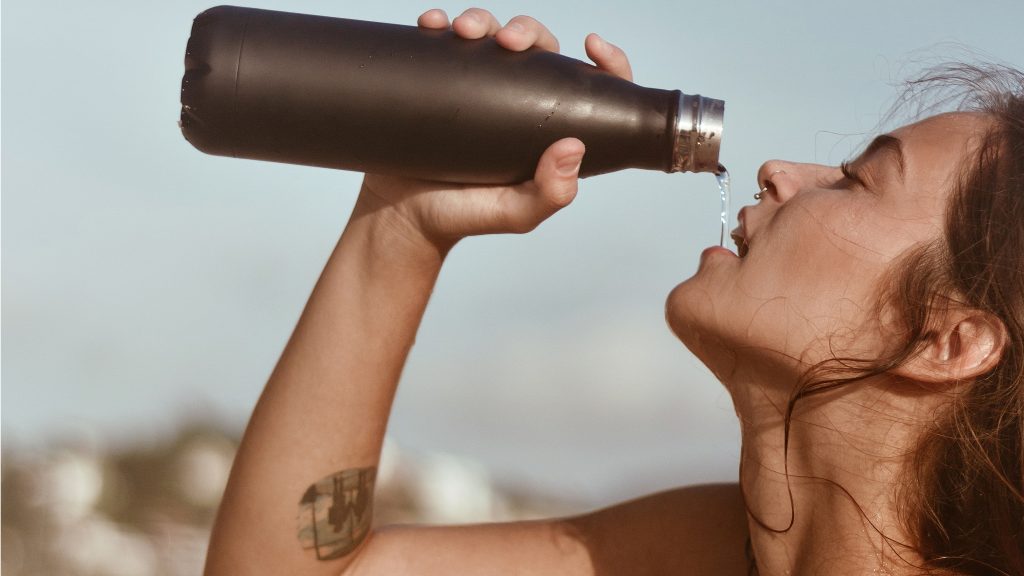 Mulher bebendo água numa garrafa