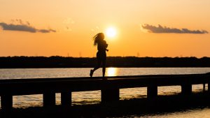 mulher-correndo-nascer-do-sol-como-acordar-cedo-para-treinar
